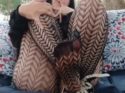 Smokes a cigarette and teases with fishnets and daisy dukes outside