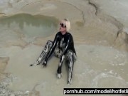 Super Hot Blond Girl In Black Latex Catsuit + High Heels And Sunglasses Bathes In The Mud - Mud Bath 10/16