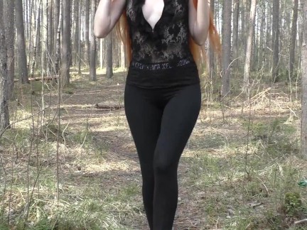 Fille rousse aux cheveux longs marchant dans le parc