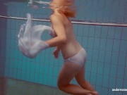 In the indoor pool, a stunning girl swims 1/16