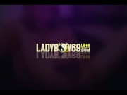 Brunette ladyboy in purple lingerie teases with her big tits in bed 1/16